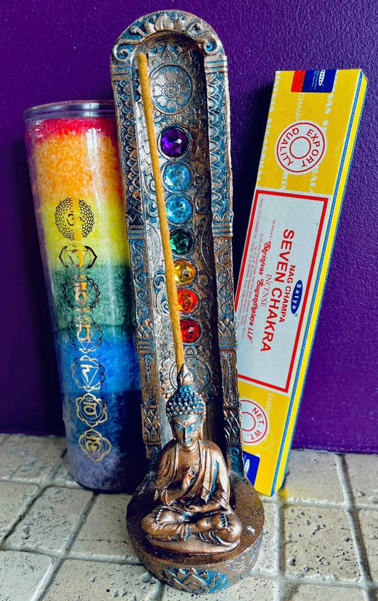 Photo of a vertical incense stick ash catcher next to a chakra candle and box of incense.