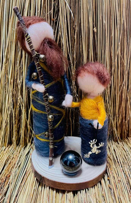 Photo of a handmade felt male witch with brown hair and beard in black robe and son with brown hair in black robe.