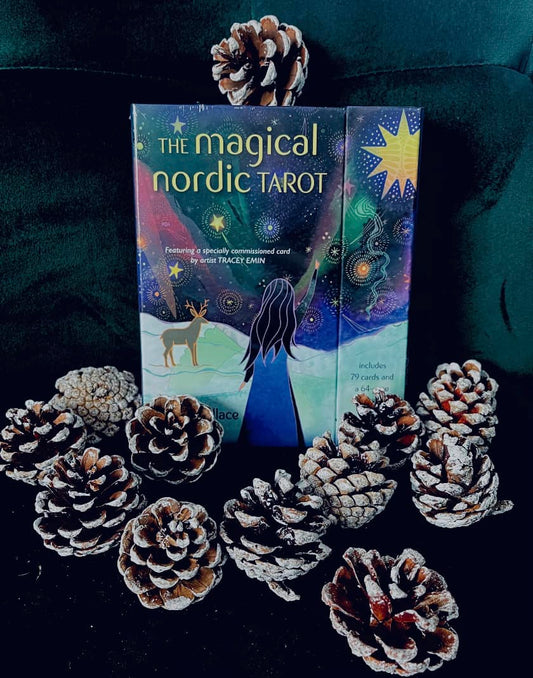 Photo of the box set for The Magical Nordic Tarot against a dark green background and surrounded by pine cones.