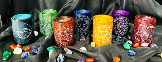 Photo of 7 different coloured chakra soapstone oil burners, one for each chakra type.