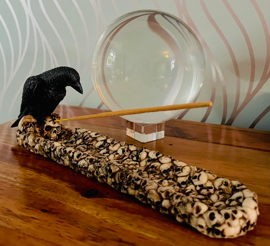 Photo of an incense holder made up of tiny skills with a raven figure sitting at the head.