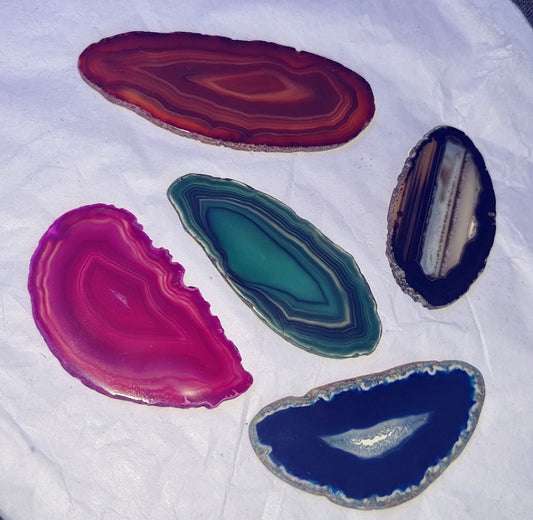 Photo of five different coloured small agate slices.