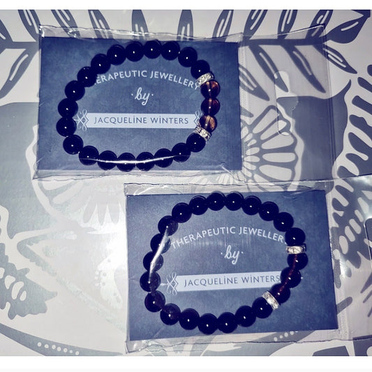Photo shows two cards saying "Therapeutic Jewellery by Jacqueline Winters" with black agate & smoky quartz bracelets attached