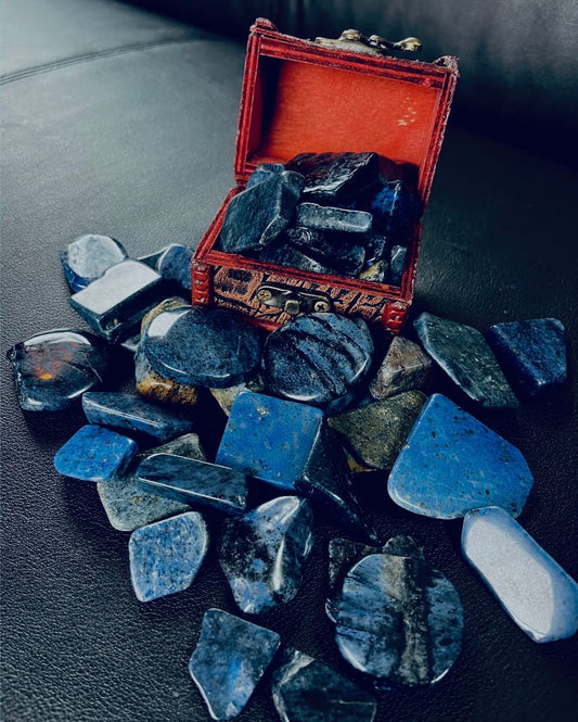 Photo of a number of dumortierite tumblestones in and next to a miniature chest.