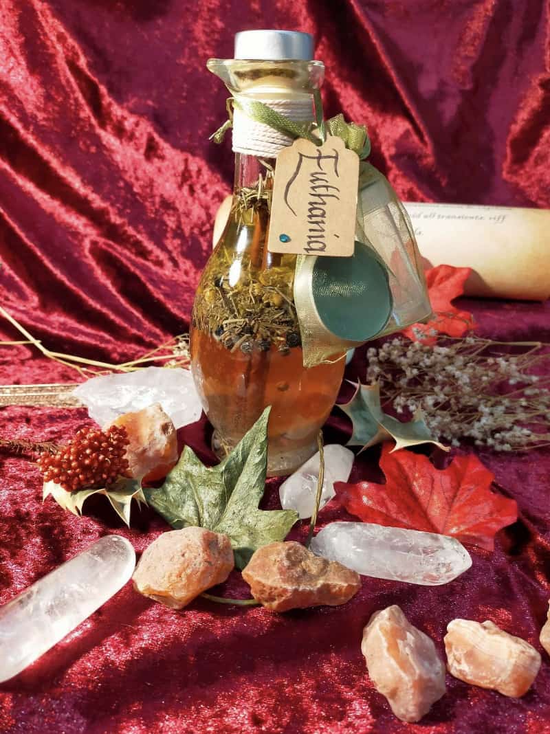 Image of a bottle of bath oil labelled Euthania, containing herbs and flowers.