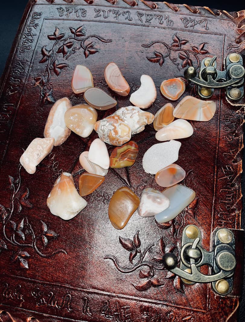 Photo of a number of pieces of Scottish agate atop a brown leather journal.