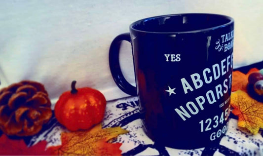 Photo of a black mug with a white Ouija board design on it - side view