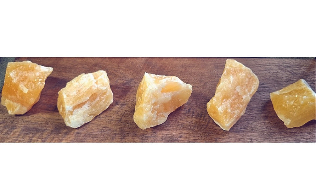 Photo of three pieces of calcite orange rough stone.