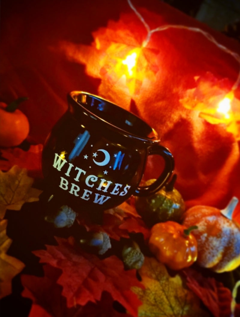 Photo of a black cauldron-shaped mug with white text reading "Witches Brew"