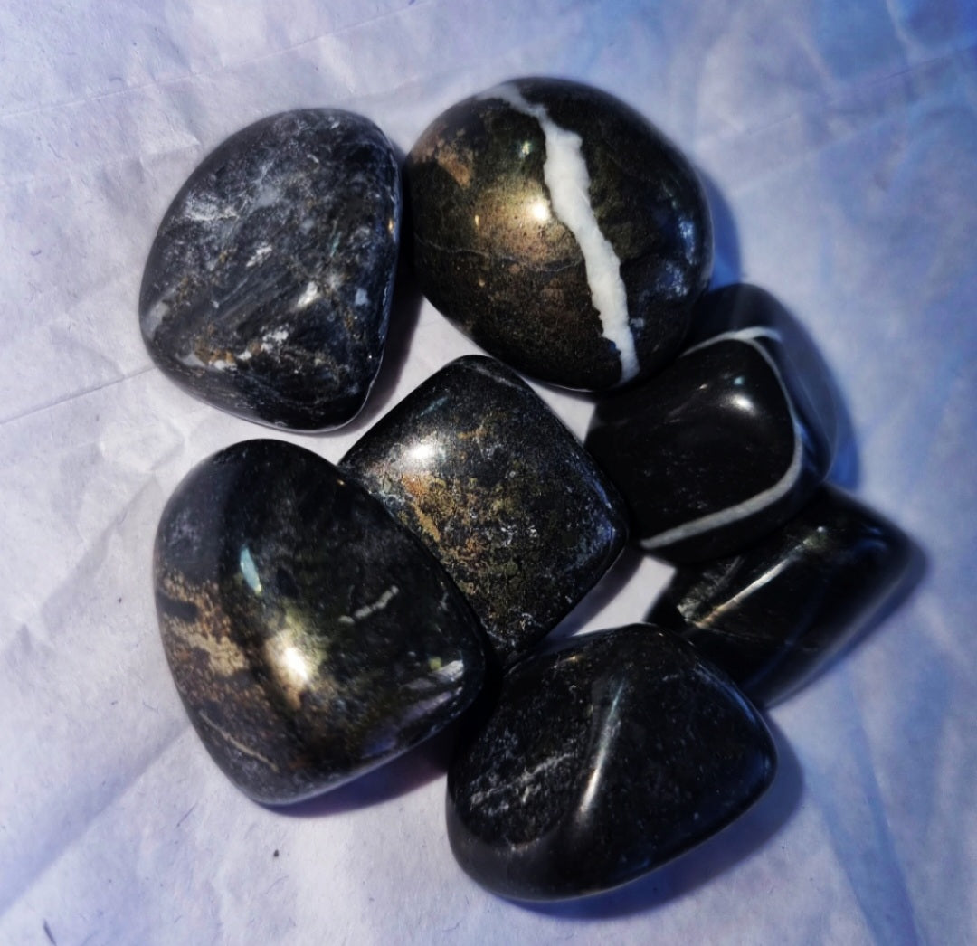 Photo of a several black and gold onyx tumblestones.