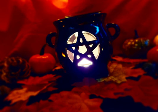 Photo of a black oil burner with a hallowed out pentagram shape at the front