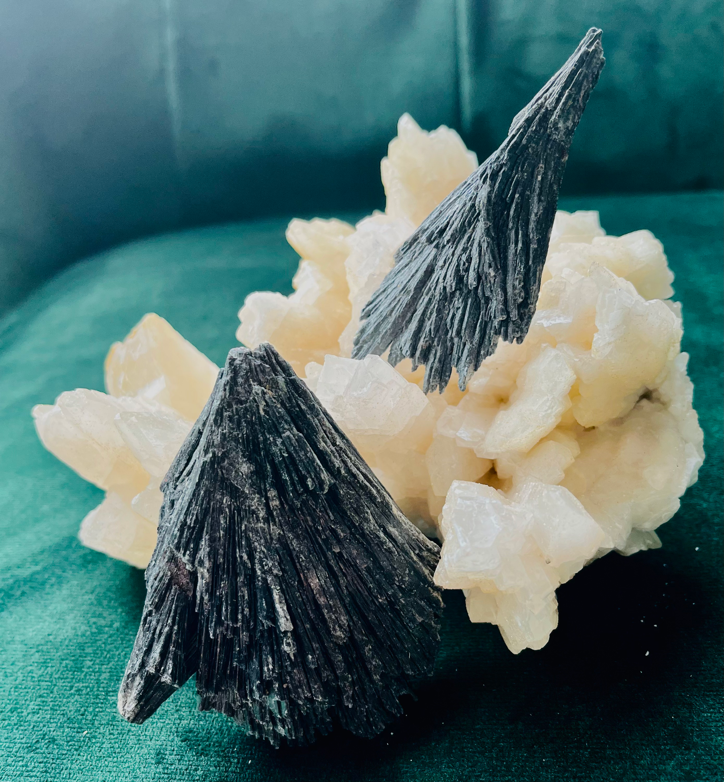 Photo of two broomstick style pieces of kyanite atop a larger stone.