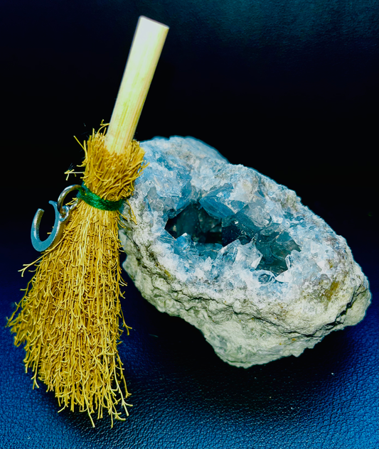 Photo of a celestite geode with a miniature broomstick next to it.