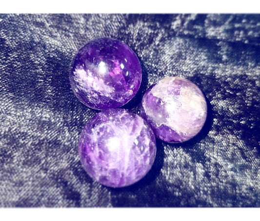 Photo of three amethyst orbs.